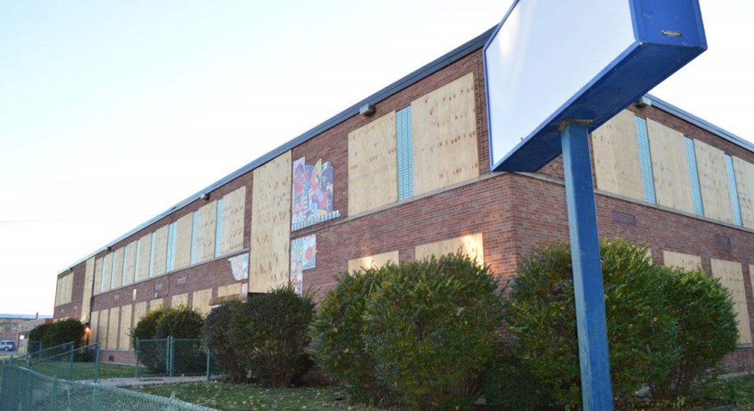 A closed CPS school has its windows and doors boarded up with plywood.
                  