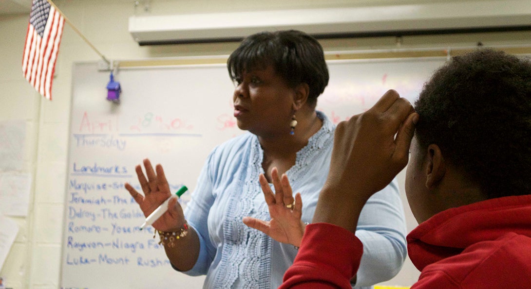 Teacher Debra Thomas leads a discussion in a self-contained special education classroom as one student listens to her speak.