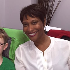 Chrisna Perry sits on a chair with a student next to her.  She is working on a special education plan for the student.