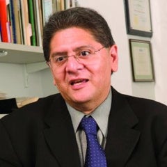 Leonard Ramirez speaks to two colleagues in his office.