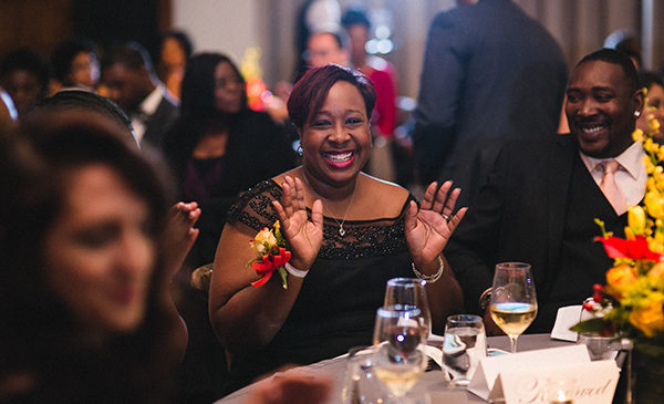 Alumna Carlitta Tucker-Powell acknowledges the applause of fellow guests while sitting at a table, having been recognized as one of the College of Education's 2015 Alumni Honors recipients.