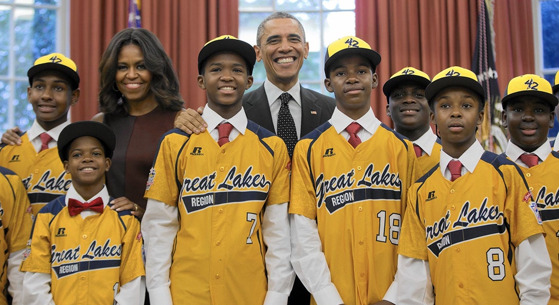 Kids on the Jackie Robinson little league team from Chicago pose with President Obama and First Lady Michelle Obama in the Oval Office.
                  