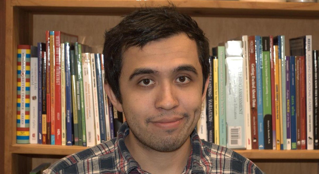 Ramon Gutierrez stands in front of a bookcase in a classroom in the College of Education building.