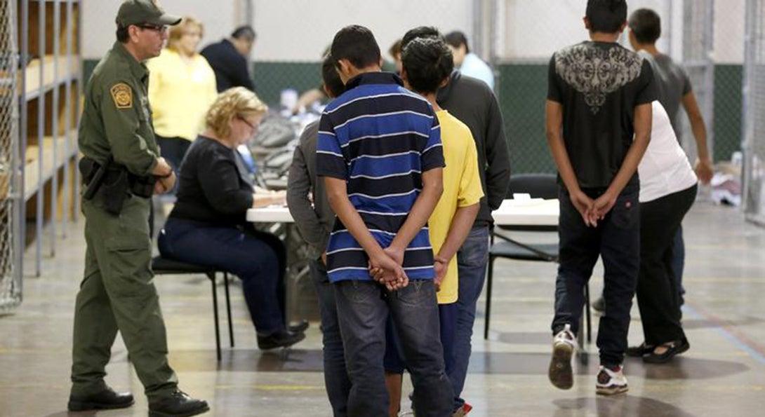 Undocumented and unaccompanied children are at an immigration detention facility, standing in line and waiting for their information to be taken down.