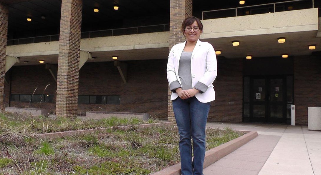 Zayoni Torres stands outside the College of Education building, posing for a photo.