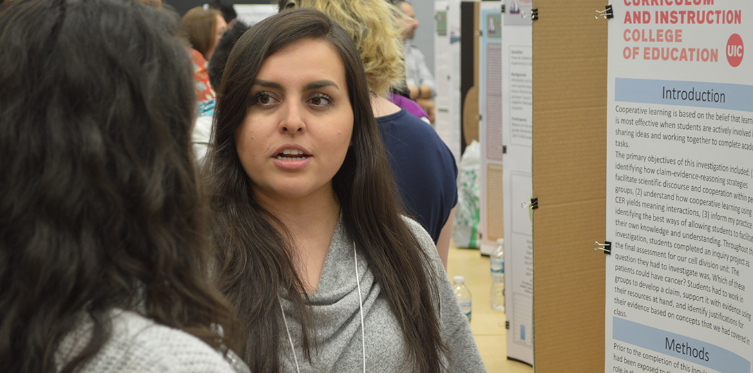 SEEEC Teaching Fellow Angela Frausto converses with another fellow while explaining her poster presentation.