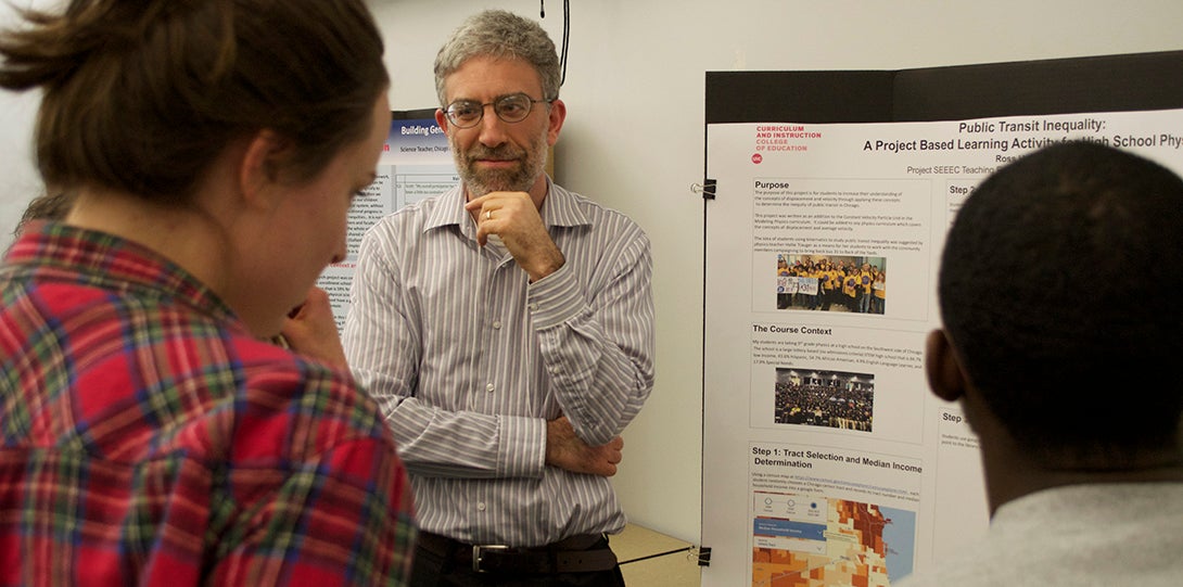 SEEEC Teaching Fellow Ross Hyman listens to a fellow student while explaining her poster presentation.