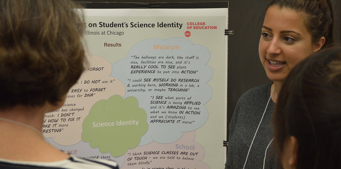 SEEEC Teaching fellow Ayesha Qazi smiles while standing in front of her poster and explaining her presentation to two other fellows.