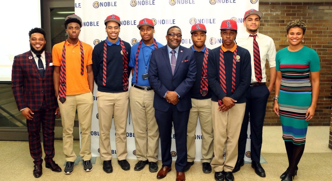 Dean Tatum stands in the middle of the Call Me MiSTER scholarship winners as well as principal Charles Goins and Noble Network CEO Constance Jones