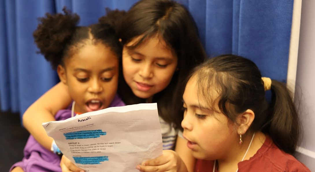Third grade students read a script together